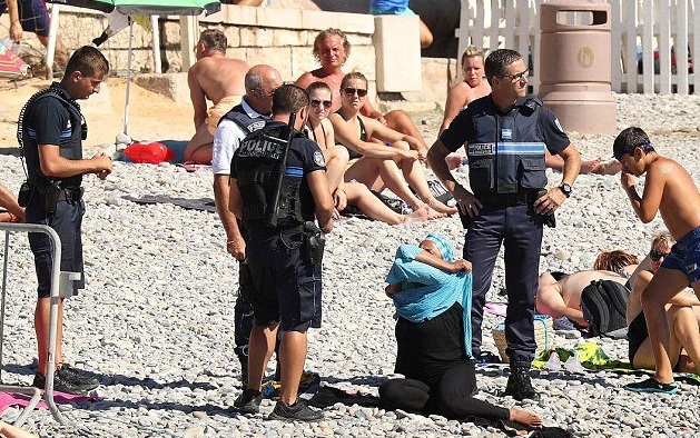 Politisti francezi obliga o femeie musulmana sa isi dea jos costumul burkini pe o plaja din Nisa!