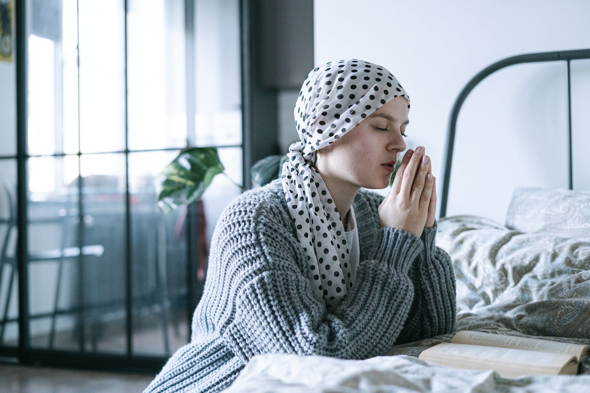 woman in gray knit sweater praying