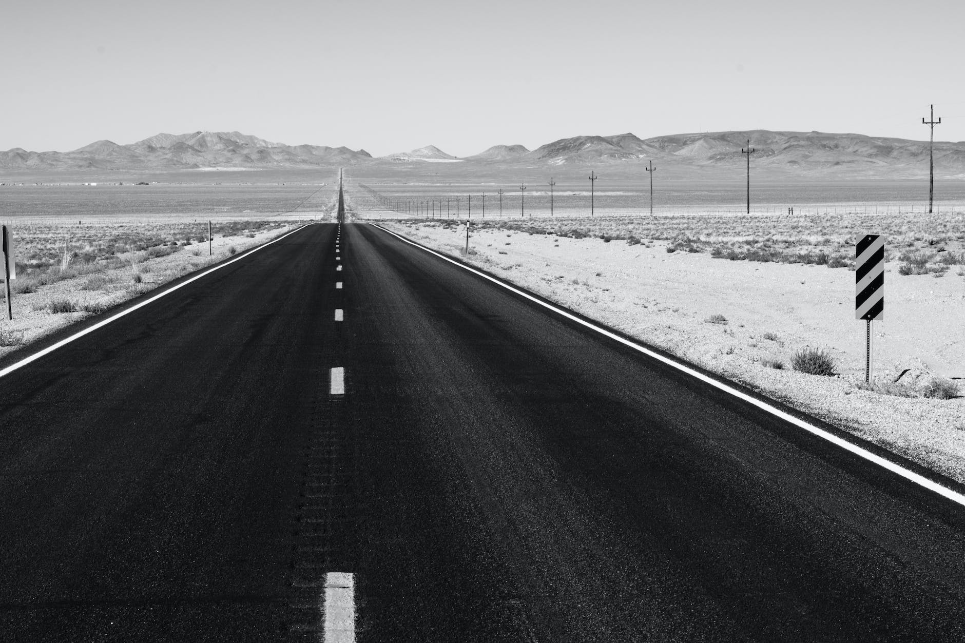grayscale photo of road on desert