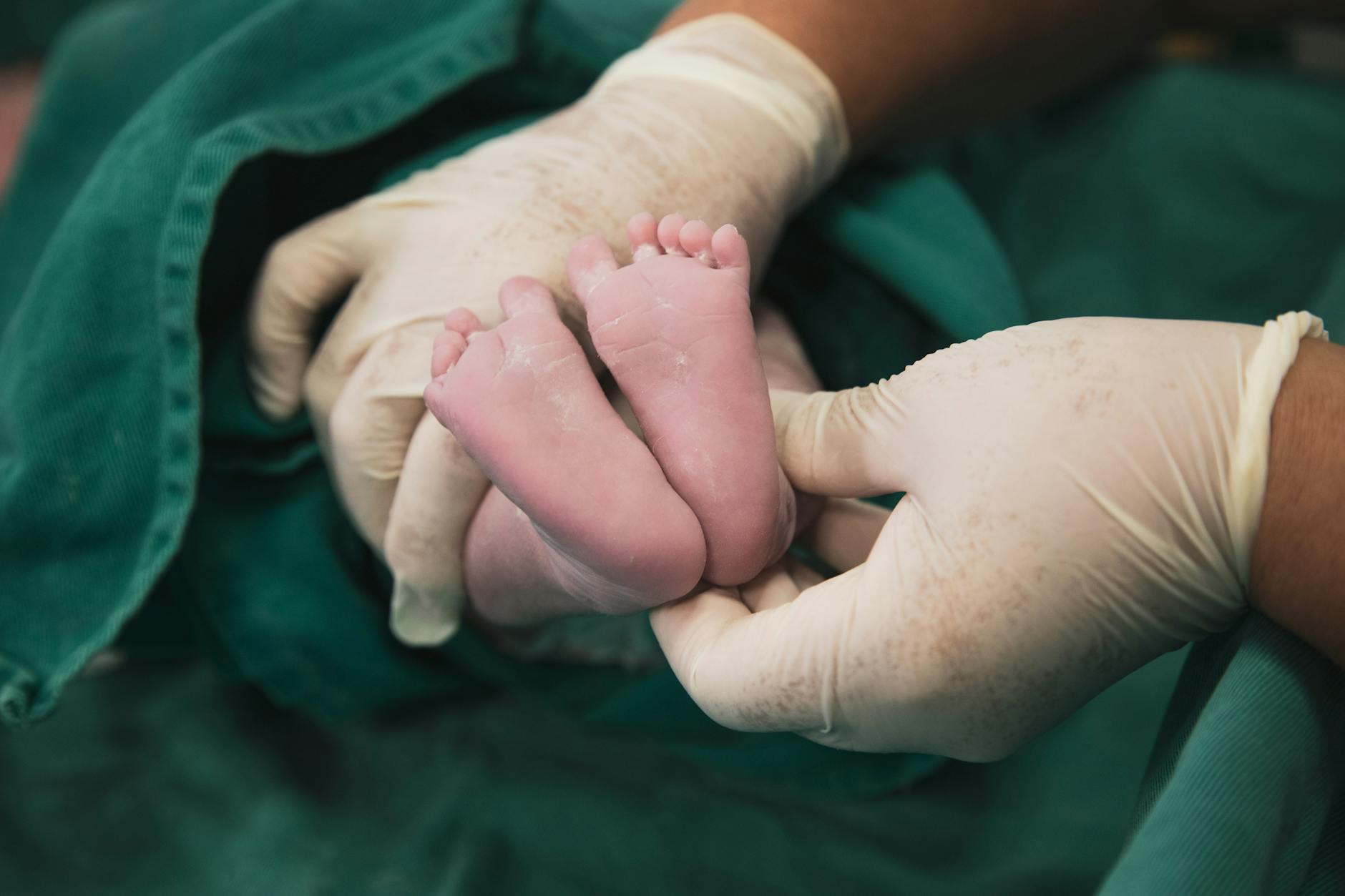 midwife holding newborn babys legs