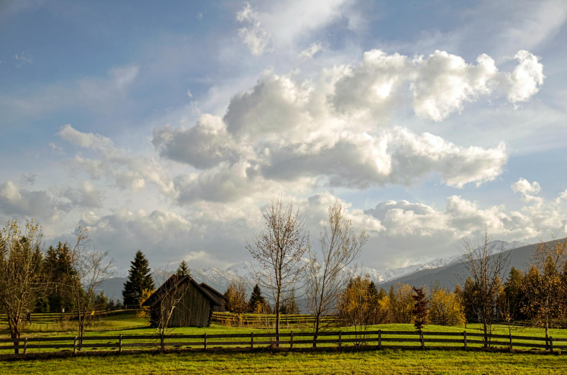 a farm with a fence and a barn in the background