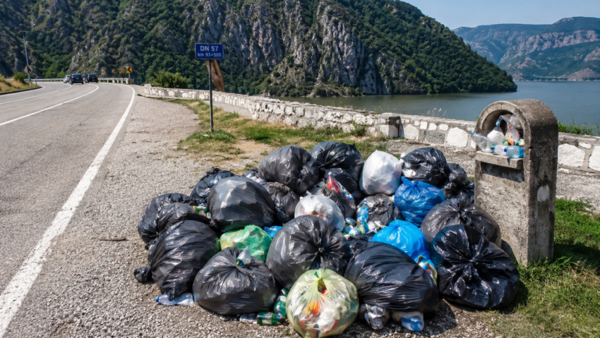 Zeci de saci cu deșeuri abandonați pe DN57, în Clisura Dunării